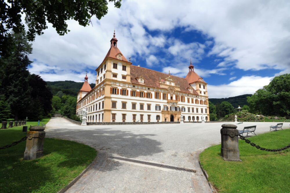 Symmetrical Baroque facade and corner towers of Eggenberg Palace under a blue sky in Graz, Austria