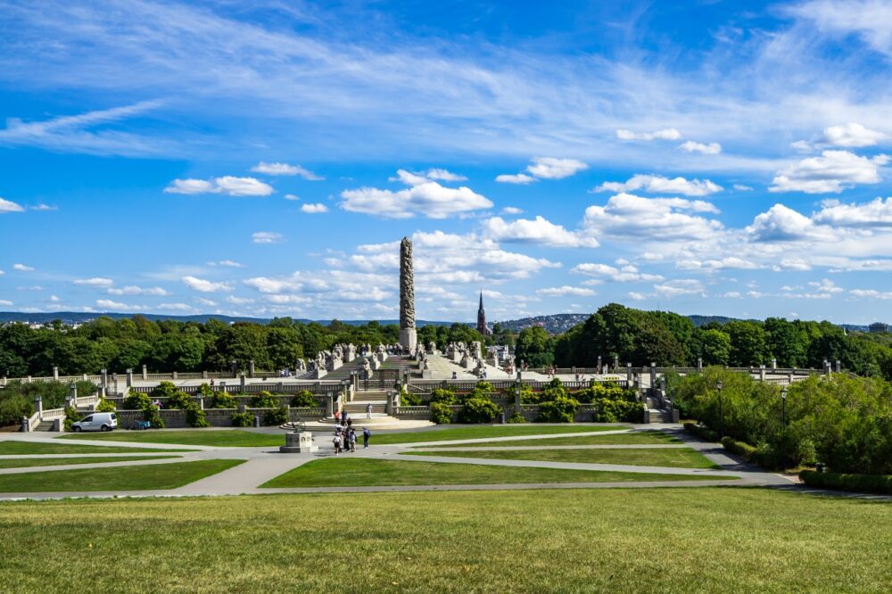 Carved granite Monolith column and tiered fountain surrounded by green lawns in Vigeland Park, Oslo, Norway